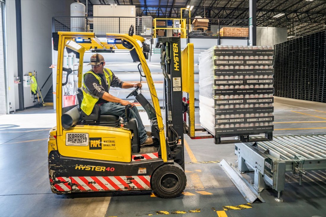 Forklift moving palletised goods inside a distribution warehouse